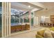 A living room and dining room open through sliding glass doors to an outdoor patio area featuring an infinity pool at 16419 Kendleshire Ter, Lakewood Ranch, FL 34202
