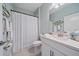 Bright bathroom featuring a white vanity, decorative fish art, and a shower with a patterned curtain at 17216 Star Banks St, Wimauma, FL 33598