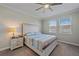 Relaxing bedroom with natural light, a ceiling fan, and a decorative lamp on a nightstand at 17216 Star Banks St, Wimauma, FL 33598