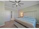 Bright bedroom featuring a ceiling fan, large bed and views into an ensuite bathroom at 17216 Star Banks St, Wimauma, FL 33598