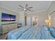 Well-lit bedroom featuring a ceiling fan, dresser, and view into an ensuite bathroom at 17216 Star Banks St, Wimauma, FL 33598