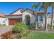 Well-maintained single-story home featuring tropical landscaping, tile roof, and paver driveway at 17216 Star Banks St, Wimauma, FL 33598