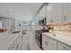 Bright kitchen features stainless steel appliances, white cabinets, stone countertops, and an eat-in table at 17216 Star Banks St, Wimauma, FL 33598