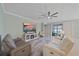 Bright living room features a modern ceiling fan, fireplace and sliding glass doors to the outdoor patio at 17216 Star Banks St, Wimauma, FL 33598