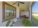 A covered patio featuring comfortable seating, plants, and views of the lawn at 17216 Star Banks St, Wimauma, FL 33598