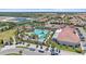 High aerial view of the sparkling community pool area with sun loungers and lush landscaping at 17216 Star Banks St, Wimauma, FL 33598