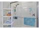 Modern bathroom featuring a tiled shower with glass doors and shelving for storage at 17216 Star Banks St, Wimauma, FL 33598