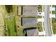 Aerial view of rooftops, green lawns, and driveways of homes located next to a small pond on a sunny day at 17715 Cantarina Cv, Bradenton, FL 34211