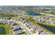 Panoramic aerial view of the neighborhood featuring a central pond and lush landscaping at 17715 Cantarina Cv, Bradenton, FL 34211