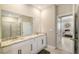 Bathroom with double-sink vanity with marble countertop adjacent to a door that leads to the bedroom at 17715 Cantarina Cv, Bradenton, FL 34211