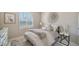 Inviting bedroom features a plush bed, stylish rug, and a sunlit window with shutters at 17715 Cantarina Cv, Bradenton, FL 34211
