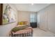 Cozy bedroom with twin bed, colorful artwork, and natural light from the window at 17715 Cantarina Cv, Bradenton, FL 34211