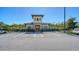 Exterior shot of a community clubhouse featuring an intricate stone facade, ample parking, and lush landscaping at 17715 Cantarina Cv, Bradenton, FL 34211