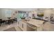 Kitchen with a granite countertop island, stainless steel appliances, and an adjacent dining and living area at 17715 Cantarina Cv, Bradenton, FL 34211