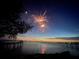 Spectacular fireworks over the water illuminate the night sky, reflecting on the pier and calm waters at 1815 Palma Sola Blvd, Bradenton, FL 34209