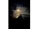 Night scene of a serene waterfront featuring a tranquil pier under the soft glow of the moon at 1815 Palma Sola Blvd, Bradenton, FL 34209