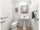 Clean powder room featuring a pedestal sink, toilet, and decorative mirror at 1904 Hyde Park St, Sarasota, FL 34239