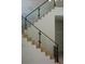 Modern staircase with wooden steps, a black handrail, and glass panels at 212 S Renellie Dr, Tampa, FL 33609