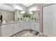 Bright bathroom with double vanity, granite countertop, decorative wall mirror, and wooden tile flooring at 22209 Deer Pointe Xing, Bradenton, FL 34202