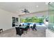 Covered outdoor patio with dining set overlooks the pool, lush landscaping, and screened-in lanai at 22209 Deer Pointe Xing, Bradenton, FL 34202