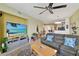 Open living room with ceiling fan, modern decor, TV, and view into kitchen at 2715 Terra Ceia Bay Blvd # 202, Palmetto, FL 34221