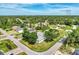 High-angle view of a home with manicured lawn and mature trees, close to neighborhood streets at 3514 Laslo Ave, North Port, FL 34287