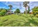 Expansive backyard features lush lawn, mature palms, gazebo and an American flag at 3514 Laslo Ave, North Port, FL 34287