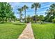Expansive backyard with a brick pathway leading to a charming gazebo and verdant lawn at 3514 Laslo Ave, North Port, FL 34287