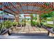 Relaxing backyard featuring a wooden pergola, swing, and patio, surrounded by lush landscaping at 3514 Laslo Ave, North Port, FL 34287