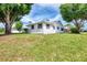 Side view of home featuring clean white siding, dark shutters, and a well-groomed lawn at 3514 Laslo Ave, North Port, FL 34287