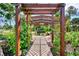 Tranquil backyard featuring a wooden pergola with hanging swing surrounded by lush greenery at 3514 Laslo Ave, North Port, FL 34287