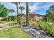 Beautifully landscaped backyard featuring a pergola with mosaic art and vibrant green foliage at 3514 Laslo Ave, North Port, FL 34287