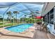Sparkling enclosed pool area, with lounge chairs, dining and lush landscaping, perfect for relaxation at 3514 Laslo Ave, North Port, FL 34287
