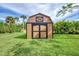 Backyard storage shed features painted wood, double doors and an overhead gable window at 3514 Laslo Ave, North Port, FL 34287