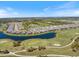 Beautiful aerial view of homes lining a lake and golf course with lush green fairways at 3564 Santa Caterina Blvd, Lakewood Ranch, FL 34211