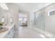 A bright bathroom with white cabinets, a large glass shower, and views into the main bedroom at 3564 Santa Caterina Blvd, Lakewood Ranch, FL 34211