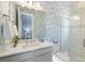 Stylish bathroom with blue wallpaper, white vanity, and a glass-enclosed shower at 3564 Santa Caterina Blvd, Lakewood Ranch, FL 34211