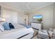 A modern bedroom features a bed with blue pillows, a TV, and white accents at 3564 Santa Caterina Blvd, Lakewood Ranch, FL 34211