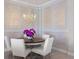Formal dining room with elegant chandelier, seating for four, and beautiful wall trim at 3564 Santa Caterina Blvd, Lakewood Ranch, FL 34211