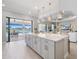 Kitchen island with modern lighting, direct view to outdoor space, and open to the living room at 3564 Santa Caterina Blvd, Lakewood Ranch, FL 34211