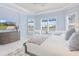 Elegant main bedroom offers natural light, blue accents, and a tranquil view of the surrounding landscape at 3564 Santa Caterina Blvd, Lakewood Ranch, FL 34211