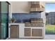 An outdoor kitchen boasts stainless steel appliances, a built-in grill, and countertop sink at 3564 Santa Caterina Blvd, Lakewood Ranch, FL 34211