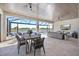 Relaxing outdoor covered patio boasts a dining area, lounge seating, ceiling fans, and scenic water views at 3564 Santa Caterina Blvd, Lakewood Ranch, FL 34211