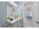 Charming powder room with blue patterned wallpaper and a white vanity at 3564 Santa Caterina Blvd, Lakewood Ranch, FL 34211