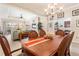 Elegant dining area featuring a wooden table, chandelier, and views of the open-concept living space at 3750 Summerwind Cir, Bradenton, FL 34209