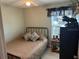 Compact bedroom with a metal bed frame, a side table, and a decorative moose sculpture at 3784 59Th W Ave # 3784, Bradenton, FL 34210
