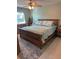 Bright bedroom featuring a ceiling fan, wooden furniture, and a cozy bed with stylish bedding at 3784 59Th W Ave # 3784, Bradenton, FL 34210