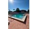 Community pool on a clear, sunny day surrounded by a brick patio and landscaping at 3784 59Th W Ave # 3784, Bradenton, FL 34210