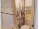 Bathroom with white tiled shower, floral curtain, and built-in shelving at 3790 Pinebrook Cir # 103, Bradenton, FL 34209