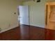 Spacious bedroom with wood floors leading to an open doorway revealing an en-suite bathroom at 3790 Pinebrook Cir # 103, Bradenton, FL 34209